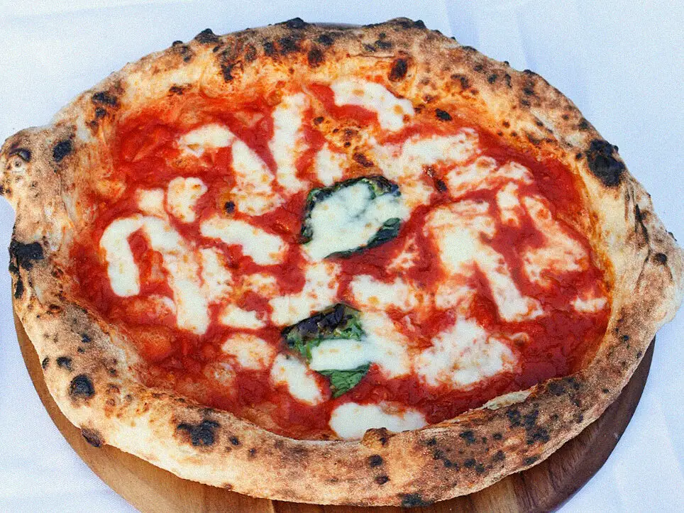 A leoparded Neapolitan margherita on a wooden board